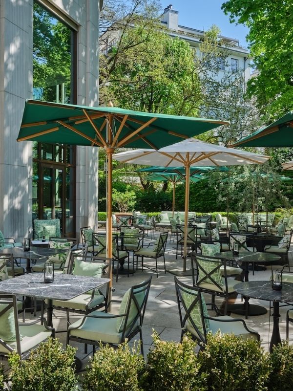 Summer Tables in München: Restaurantbereich des Florio mit grünen Schirmen, Stühlen und Tischen